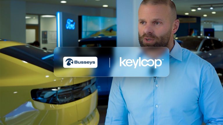 A man in a blue shirt talking to camera whilst sitting in a Ford Busseys car dealership. The image also has the Busseys and Keyloop dual branded logo.